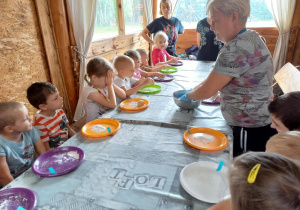 Dzieci uczestniczą w warsztatach wyrobu chleba.