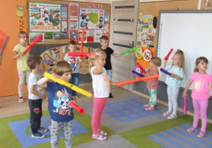 Dzieci wykonują ćwiczenia ruchowe z wykorzystaniem bum-bum rurek.