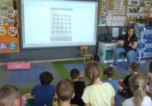 Dzieci oglądają muzogram wyświetlany na tablicy multimedialnej.