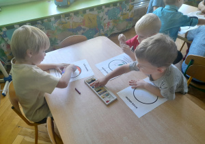 Dzieci kolorują pastelami swoje kropki.