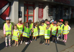 Dzieci czekają przy przejściu dla pieszych na zielone światło sygnalizacji.