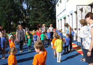 Dzieci tańczą na tarasie przedszkolnym.