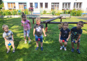 Dzieci wykonują ćwiczenia w ogrodzie.