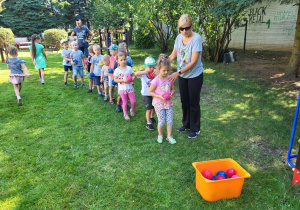 Dzieci wykonują ćwiczenia w ogrodzie.