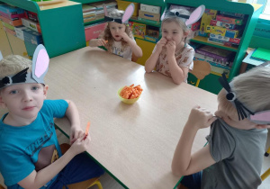 Dzieci jedzą marchewki.