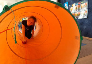 Dziewczynka w tunelu z piłką.