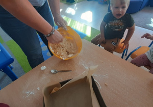 Nauczycielka pokzauje dzieciom ciasto.