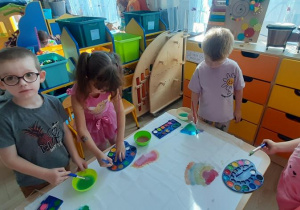 Dzieci malują techniką "mokre w mokre".