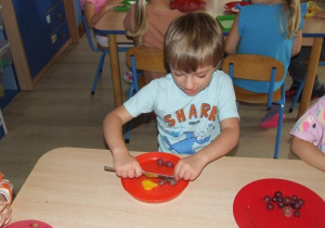Dzieci kroją owoce na sałatkę.