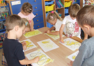 Dzieci zamalowują kształty owoców.