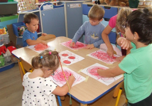 Dzieci zamalowują kształty owoców.