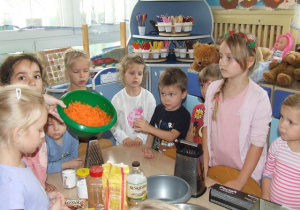 Dzieci oglądają składniki na ciasto.