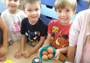 Chłopcy przygotowują jajka do ciasta.