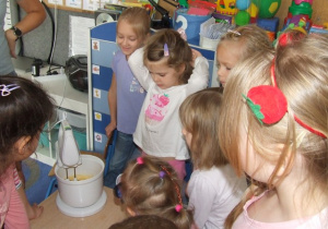 Dzieci obserwują jak mikser łączy składniki na ciasto.