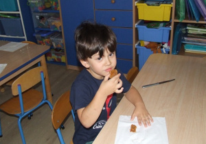 Chłopiec zjada ciasto marchewkowe.