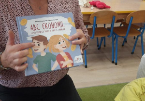 Nauczycielka prezentuje dzieciom księżkę, z której będziemy czytać opowiadania podczas zajęć projektowych.