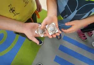 Dzieci pokazują obrazek z monetą 2.