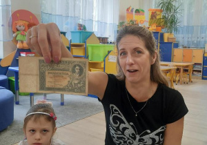 Nauczycielka prezentuje stary banknot.