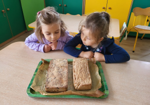 Dziewczynki oglądają upieczony chleb.