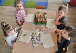 Dzieci jedzą upieczony chleb.