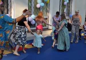 Dzieci i rodzice tańczą taniec "Belgijka".