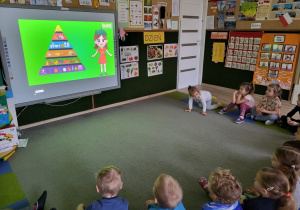 Dzieci oglądają film o zdrowej piramidzie żywienia.