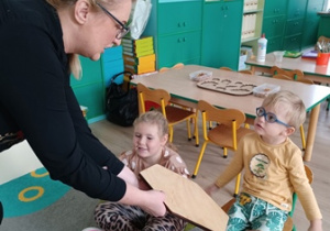 Przedszkolaki dotykają drewniane przedmioty
