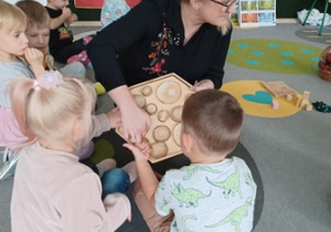 Przedszkolaki dotykają drewniane przedmioty