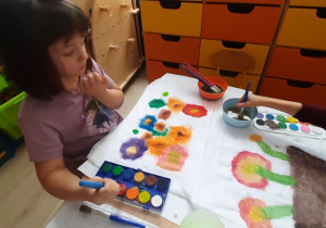 Dziewczynka podczas malowania kwiatów.