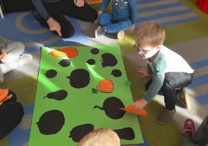 Dzieci dobierają dynie do cienia na planszy.