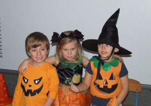 Dzieci pozują do zdjęcia w halloweenowych przebraniach.