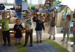 Dzieci wykonują ćwiczenia gimnastyczne zgodnie z piosenką.