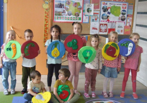 Dzieci prezentują krążki z owocami iwarzywami.