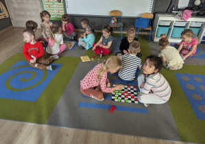 Dzieci w małych grupach grają w różne gry planszowe.