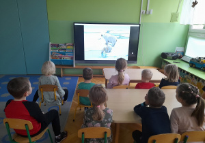 Dzieci oglądają film edukacyjny o misiach.