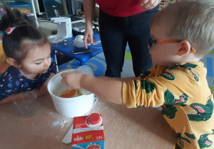 Chłopiec wlewa mleko do miski.
