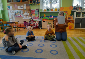 Dzieci słuchają czytającej nauczycielki.
