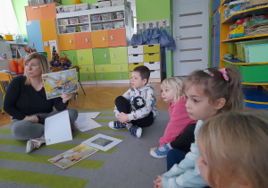 Dzieci oglądają ilustracje o pracy górnika.