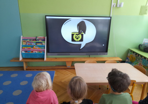 Dzieci oglądają film edukacyjny o górnikach.