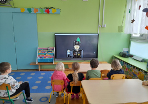 Dzieci oglądają film edukacyjny o górnikach.