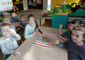 Dzieci jedzą ciasteczka.