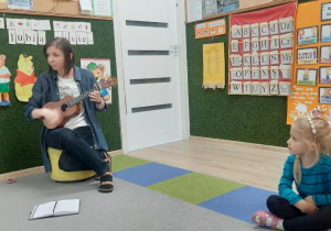 Pani nauczycielka gra na ukulele piosenkę o misiu.
