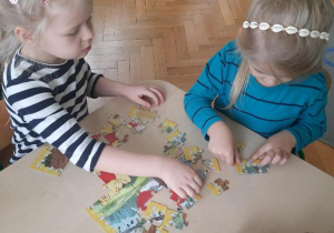 Dziewczynki układają puzzle.