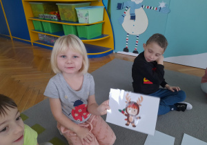 Dziewczynka pokazuje ilustrację.
