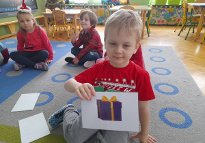 Chłopiec pokazuje ilustrację.