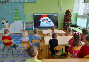 Dzieci oglądają film edukacyjny o Św. Mikołaju.