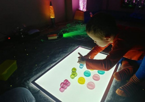 Chłopiec układa wieżę z kolorowych kostek.