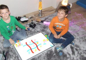 Dwóch chłopców gra w kółko i krzyżyk.