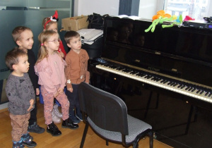 Dzieci oglądają pianino.