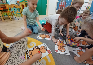 Dzieci odszukują guziki we wskazanym kształcie